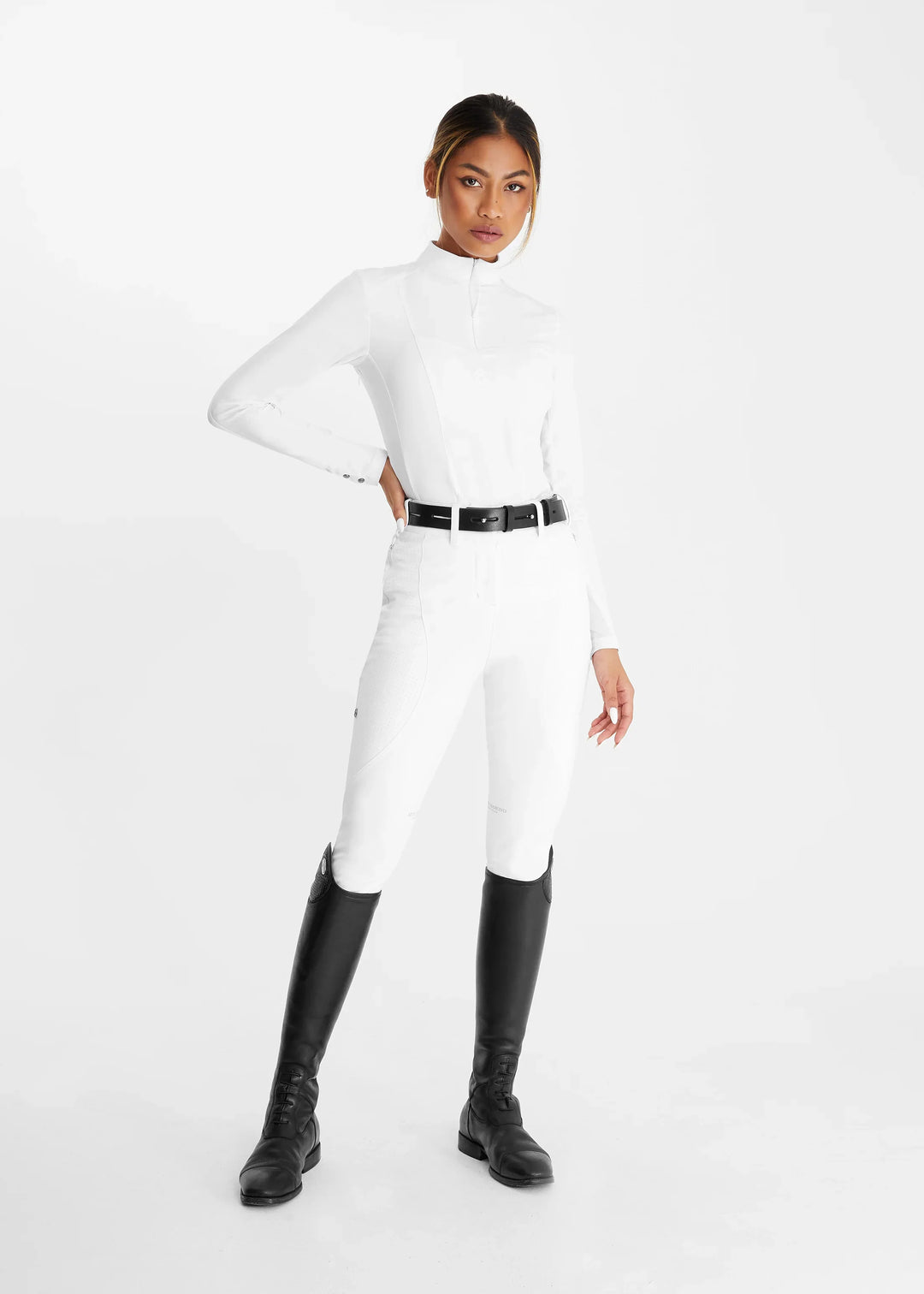 Rider wearing white competition shirt, breeches and tall boots